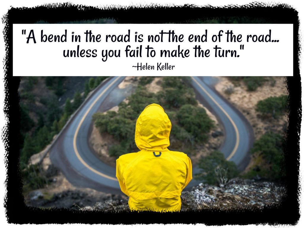 Heller Keller quote over person in yellow raincoat overlooking winding road.