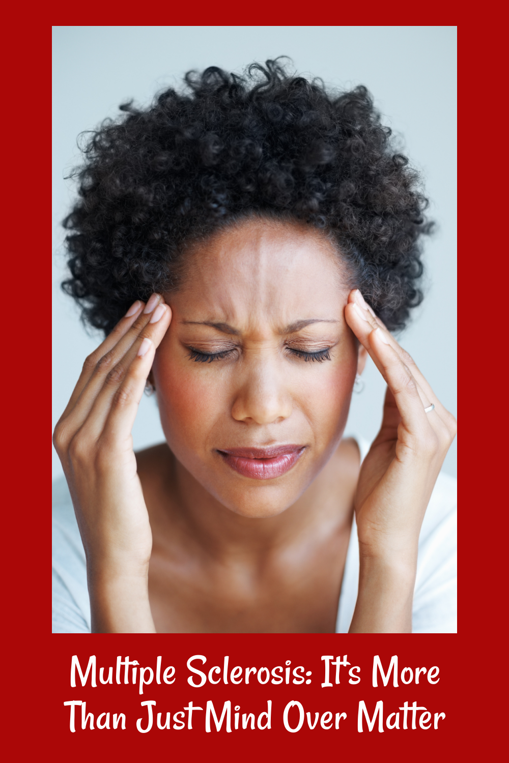 A black woman with her hands rubbing her temples.